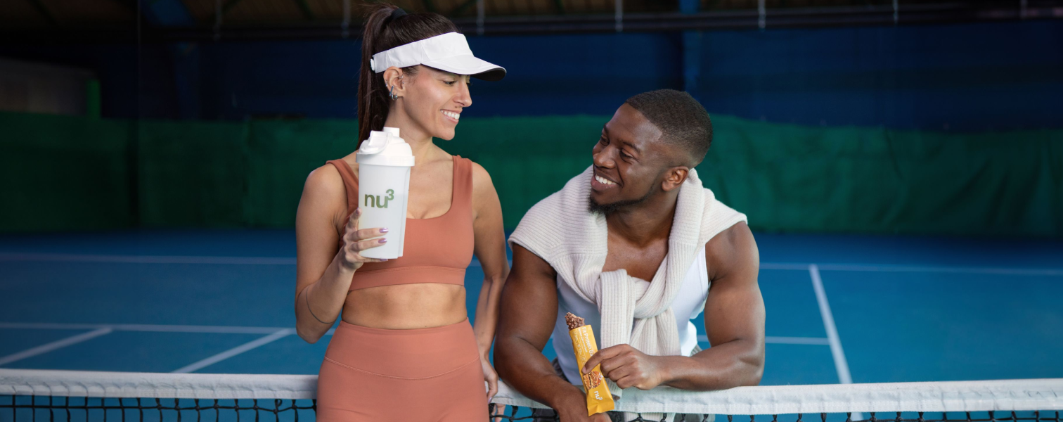 Homme et femme souriant avec un shake et une barre protéinée