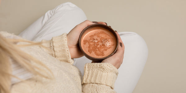 Femme tenant une tasse de cacao protéiné